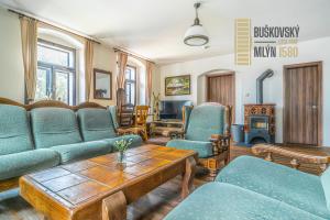 a living room with blue couches and a table at Buškovský mlýn 1580 in Dolní Bousov