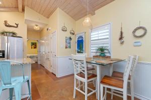 Una cocina y un comedor con mesa y sillas. en Mango Bungalow - Sleeps 8 2 Community Pools, en Port Aransas