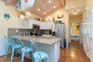 una cocina con encimera con sillas azules. en Mango Bungalow - Sleeps 8 2 Community Pools, en Port Aransas 34 fotos más