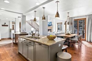 a kitchen with a table and a dining room at Calming Canyons - Ski-in Ski-out Luxe Penthouse in Park City