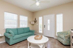 a living room with a green couch and a table at Fun 2 bedroom - Pets Pool Sleeps 6 in Port Aransas