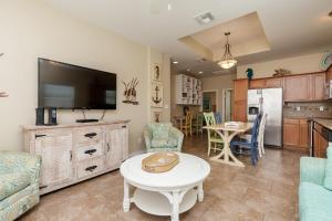 a living room with a tv and a table at Fun 2 bedroom - Pets Pool Sleeps 6 in Port Aransas +19 photos