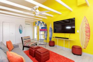 a living room with a yellow wall with surfboards at Stylish 3 bedroom - Pool Pets Sleeps 10 in Port Aransas