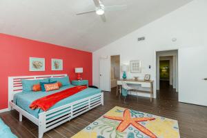 a bedroom with a bed and a red wall at Stylish 3 bedroom - Pool Pets Sleeps 10 in Port Aransas