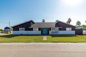 a house with a blue door on a street at Stylish 3 bedroom - Pool Pets Sleeps 10 in Port Aransas