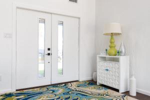 a room with a door and a lamp and a rug at Stylish 3 bedroom - Pool Pets Sleeps 10 in Port Aransas
