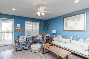 a living room with a couch and two chairs at The Oasis - Pet Friendly Optional Golf Cart in Port Aransas