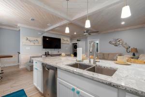 a kitchen with a sink and a living room at Modern Comfort 3 Bedroom Pets in Port Aransas