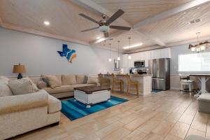a living room with a couch and a kitchen at Modern Comfort 3 Bedroom Pets in Port Aransas