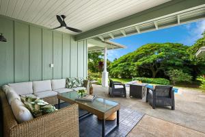 una sala de estar con un sofá y una mesa en JC Surf House, en Koloa