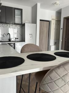 a kitchen with a counter with four chairs around it at MA Housing - Central Apartment in Cluj-Napoca