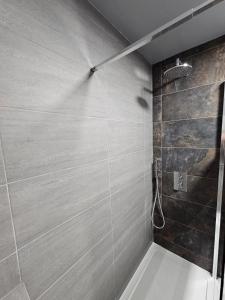 a bathroom with a shower with a white bath tub at Apartment Royston Center in Royston +8 photos