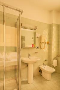 a bathroom with a sink and a shower and a toilet at Hotel Cristallo in Giulianova