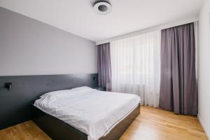 a bedroom with a white bed and a window at Ilidža Luxe Apartment in Sarajevo +8 photos