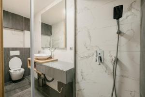 a bathroom with a shower with a sink and a toilet at Ilidža Luxe Apartment in Sarajevo