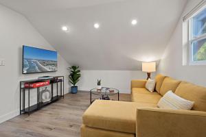a living room with a couch and a tv at Ocean-View, Deck, Steps to Beach Dining and More in Solana Beach
