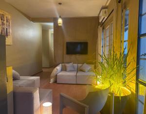 a living room with a white couch and a tv at Résidence NATANGUE 1 - Studio La Bella in Sali Nianiaral