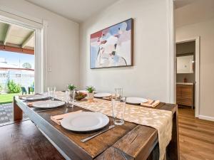 a dining room with a table with plates on it at 5BR Sleeps 10 Hot Tub Fire Pit Games & Walk to ASU in Tempe +26 photos