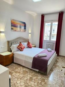 a bedroom with a large bed with red curtains at REHAN VENICE STATiON in Venice
