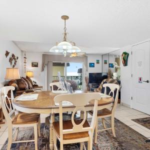 a dining room and living room with a table and chairs at Poolfront 2BR Condo with BBQ Steps To Beach & Pier in Cocoa Beach