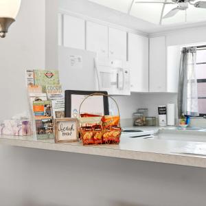a kitchen counter with a basket of food on it at 2BR Sleeps 6 Pool BBQ Steps to Beach Pier Downtown in Cocoa Beach