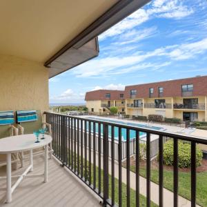 a balcony with a table and a view at Beachfront 2BR Condo with Pool BBQ & Steps To Beach in Cocoa Beach