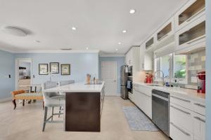 a large kitchen with white cabinets and a large island at Dolphin Villa - Private Pool in West Palm Beach