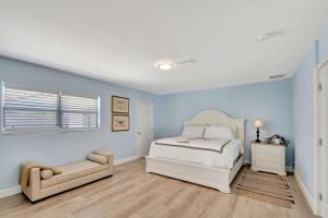 a bedroom with blue walls and a bed and a chair at Dolphin Villa - Private Pool in West Palm Beach