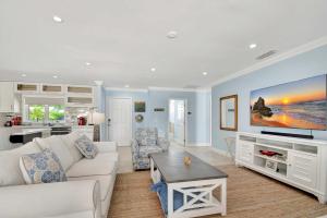 a living room with a white couch and a tv at Dolphin Villa - Private Pool in West Palm Beach +48 photos