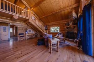 a living room with a staircase in a log cabin at Maggies Cabin - Enjoy a Slice of Paradise in Rexford Montana in Rexford