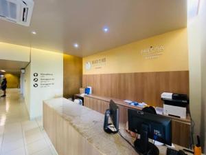 an office with a reception desk and a lobby at Beach Class Excelsior - Flat 1 quarto no Pina por Yolo in Recife +30 photos
