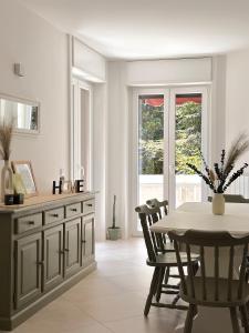 a dining room with a table and a table and chairs at Casa Bole, rustic-chic attic with lake glimpse in Dormelletto