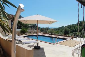 een zwembad met een parasol en een zwembad bij La Casuccia in Venzolasca