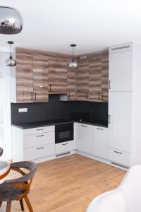 カルパチにあるApartamenty IDA - Górski Azylの白いキャビネットとテーブルと椅子のあるキッチン +24枚の写真