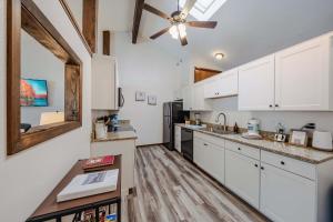 a kitchen with white cabinets and a ceiling fan at Glacier Vista Golf Getaway in West Glacier
