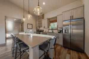 a kitchen with a table and a stainless steel refrigerator at Wilderness Club Cabin - Sleeps 7 in Eureka