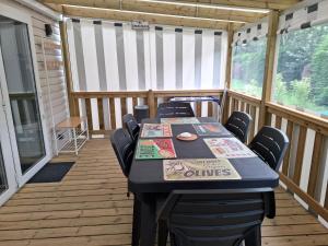 un porche cubierto con mesa y sillas en Mobil-home bord de mer, en Colleville-sur-Mer