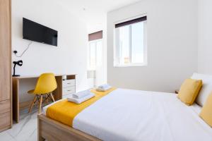 斯利马F8-2 Bedroom Ensuite Sliema的白色卧室,配有床和黄色椅子