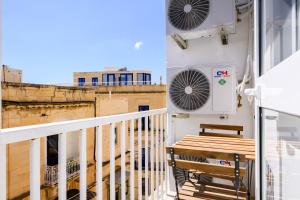 斯利马F8-2 Bedroom Ensuite Sliema的建筑物上的带长凳和空调的阳台