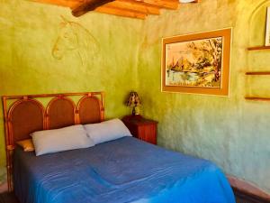 a bedroom with a bed with a horse on the wall at Yellowwood Forest Eco Retreat in Morganʼs Bay