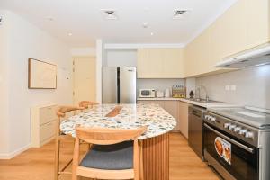 迪拜GV Holiday Homes DXB - Cozy 2BR Apartment in Town Square Dubai的厨房配有桌椅和台面