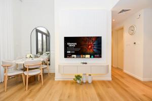 迪拜GV Holiday Homes DXB - Cozy 2BR Apartment in Town Square Dubai的墙上挂着电视的客厅