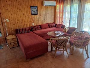 a living room with a red couch and a table at Avas Apartman in Balatonberény