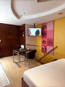 Cette chambre d'hôtel dispose d'une table à manger et d'une télévision. dans l'établissement Lumini Motel, à São Paulo 17 autres photos