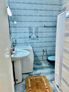 a blue tiled bathroom with a sink and a toilet at Villa Mer in Nabeul +23 photos
