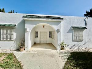 a white house with a white door and a driveway at Villa Mer in Nabeul