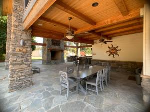 a patio with a table and chairs and a stone fireplace at Ranch stay near Sequoias in Woodlake