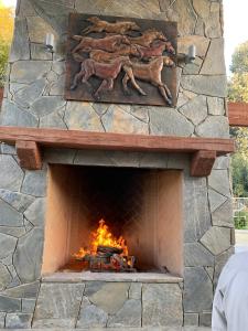 a stone fireplace with a fire in it at Ranch stay near Sequoias in Woodlake