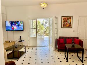 a living room with a red couch and a tv at Villa Mer in Nabeul