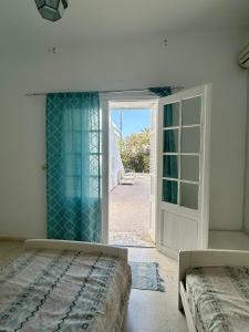 a bedroom with a bed and an open door at Villa Mer in Nabeul